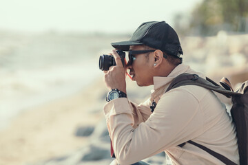 Tourists use camera to shoot sunset on the beach. backpacker and travel concept.