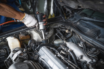 Auto mechanic replacing car engine motor mounts.