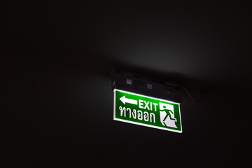 Green sign, exit sign, fire escape route, mounted on the ceiling of the building