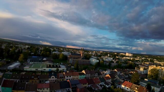 City Svitavy in the Czech Republic with family houses and real estate in an urban location with a red church in sunny autumn. Drone view at sunset