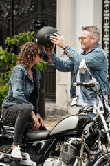 Fototapeta na wymiar Man Helping Girlfriend to Wear Motorcycle