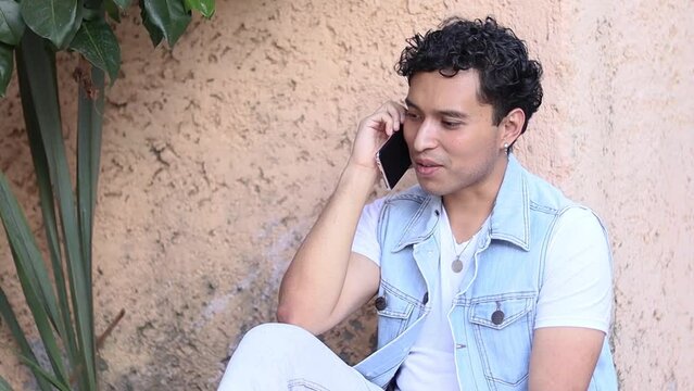 Joven hablando por tel&eacute;fono al aire libre
