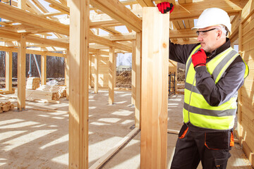 Man construction worker. Construction wooden beam. Guy builds house out wood. Construction worker...