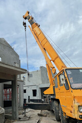 Image of truck crane machine lifting precast wall panels for housing project on site for construction industry and business technology background.