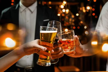 essen und trinken männliche freunde trinken gerne bier und stoßen in einer bar oder einem pub an. © maeching