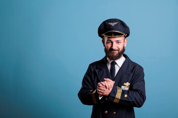 Smiling excited plane aviator in professional uniform clapping hands. Happy positive airlane pilot...