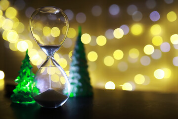Hourglass and Christmas background. Christmas, new year, copy space, bokeh.