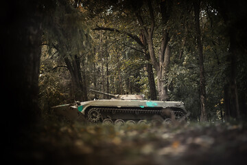 Toned photograph. A selective focus shot of an abandoned military tank in forest