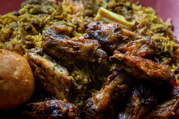 Traditional Jamaican jerk chicken wings, curried goat and fried dumpling with rice and peas