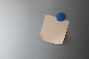 Blank paper on fridge door with blue magnet