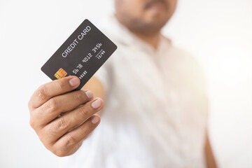 Close-up hand of Asian man holding black credit card in his hand isolated on white background. Concept of trading, social, technology, business.