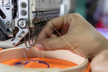 Close-up Female hand put in thread into embroidery needle