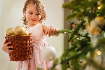 a cute little girl with toy basket for the Christmas tree.