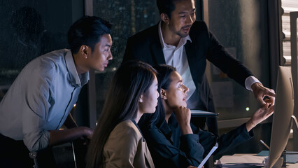 A group of businesspeople share their ideas to expedite the completion of the project until late at night.