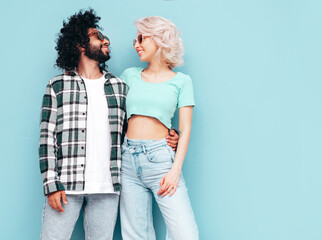 Smiling beautiful woman and her handsome boyfriend. cheerful multiracial family having tender moments on beige background in studio. Multiethnic models hugging. Embracing each other. Love concept