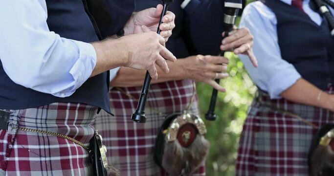 Scottish Bag pipe players close. Bagpipes are a woodwind instrument fed from a constant reservoir of air in the form of a bag. Blown by mouth or bellows.