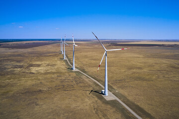 wind power plant in the steppe against the blue sky shooting from a drone