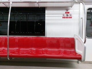 Red row of seats on the train and signs warning No eating or drinking, No Flammable goods, No...