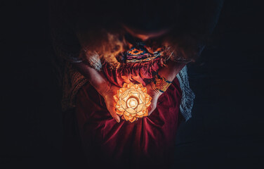 beautiful meditating woman with lotus candle in her hand.