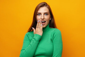 Photo of beautiful woman holding hands near mouth against yellow background