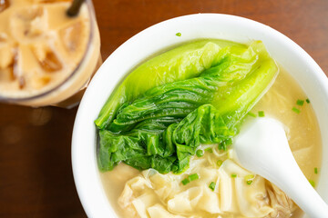 bowl of wontons with cup of iced milktea