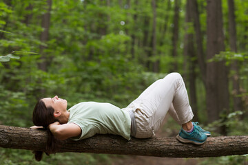  meditation. Slow life. Enjoying the little things.  middle aged woman wearing rests in the forest....