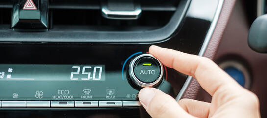 Woman hand adjusting temperature the air flowing during driving car on the road, air conditioner cooling system inside the car. Adjust, temperature and transport concept