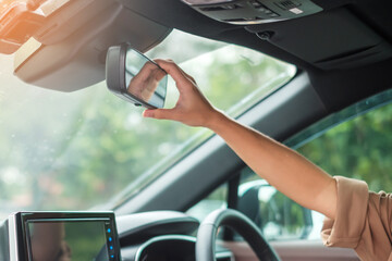 woman driver adjusting rear view mirror a car. Journey, trip and safety Transportation concepts