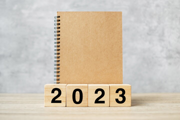 2023 Happy New Year with blank notebook and wooden number. countdown, Resolution, Goals, Plan, Action and Mission Concept