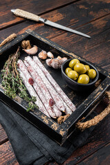Meat Charcuterie Fuet salami sausages with olives and herbs. Wooden background. Top view - obrazy, fototapety, plakaty