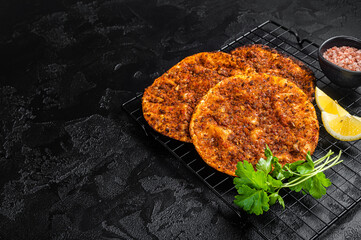 Traditional Turkish lahmacun with mince meat. Black background. Top view. Copy space