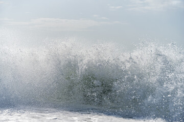 A powerful burst of wave with splashes filling the entire frame.