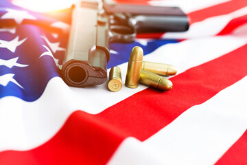 Handgun and bullet lying on USA flag