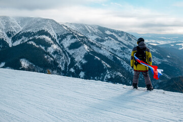 Fototapeta na wymiar man snowboarder with slovakia flag at ski resort slope