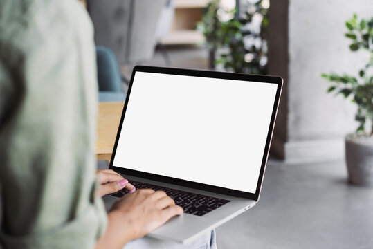 Young woman using laptop computer with empty blank mockup screen. Business woman working in office. Freelance, student lifestyle, e-learning, studying, web site, technology and online shopping concept