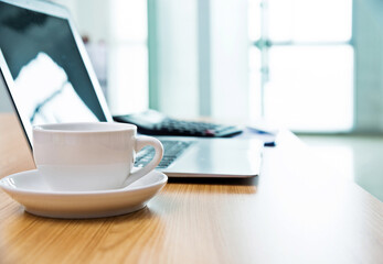 Laptop with coffee cup in office