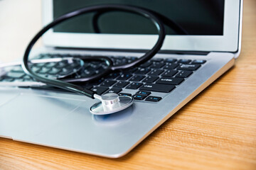 Stethoscope on keyboard of laptop