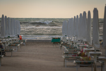 Big waves roll up on the beach. close parasol in bright Sunny day. White foaming waves and...