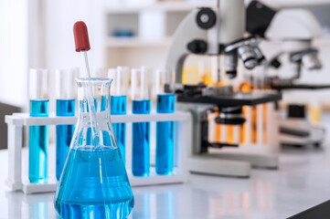 Glassware with blue liquid and equipment in chemistry science laboratory, science and medical research and development concept .