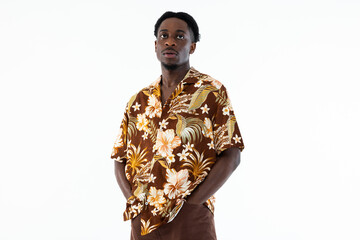 Portrait of serious african american man wearing fashionable colorful shirt holding hands in pocket isolated on white background.