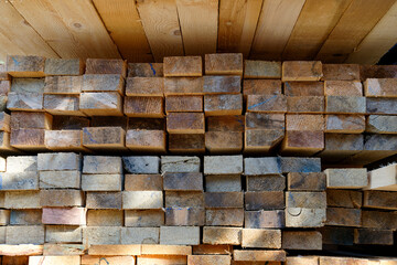 Blocks of pine sawn timber for the construction of roof houses and cottages stacked on the lumberyards site, ready for sale
