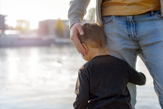 Baby Boy Embracing Fathers Leg. Man With Child Before Separation To War