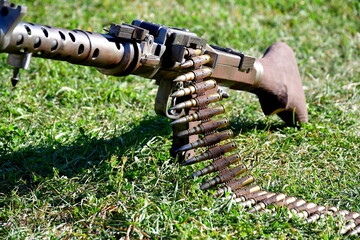 A close up on a replica of an old WWII machine gun attached to a metal frame or stand and with a...
