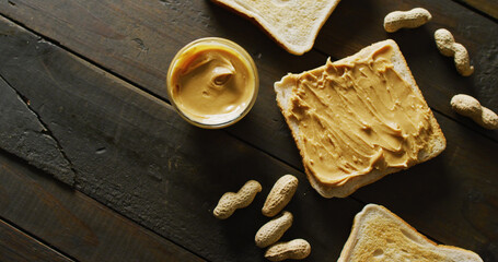 Image of close up of toasts with peanut butter on wooden background