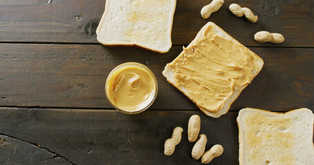 Image of close up of toasts with peanut butter on wooden background