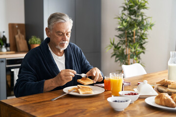 Senior caucasian man preparing breakfast at home