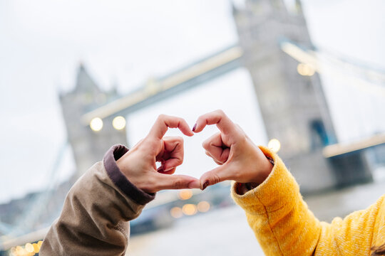 London, United Kingdom, Couple making heart-shaped finger frame