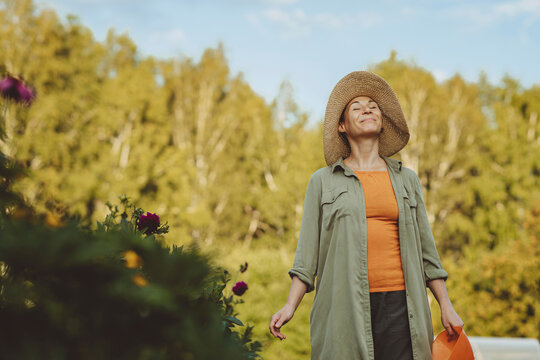 Smiling woman breathing fresh air in garden