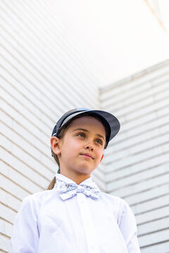 Girl wearing sun visor standing in front of white wall
