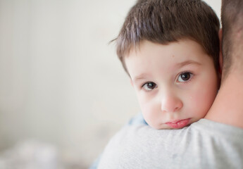 Father carrying sad boy